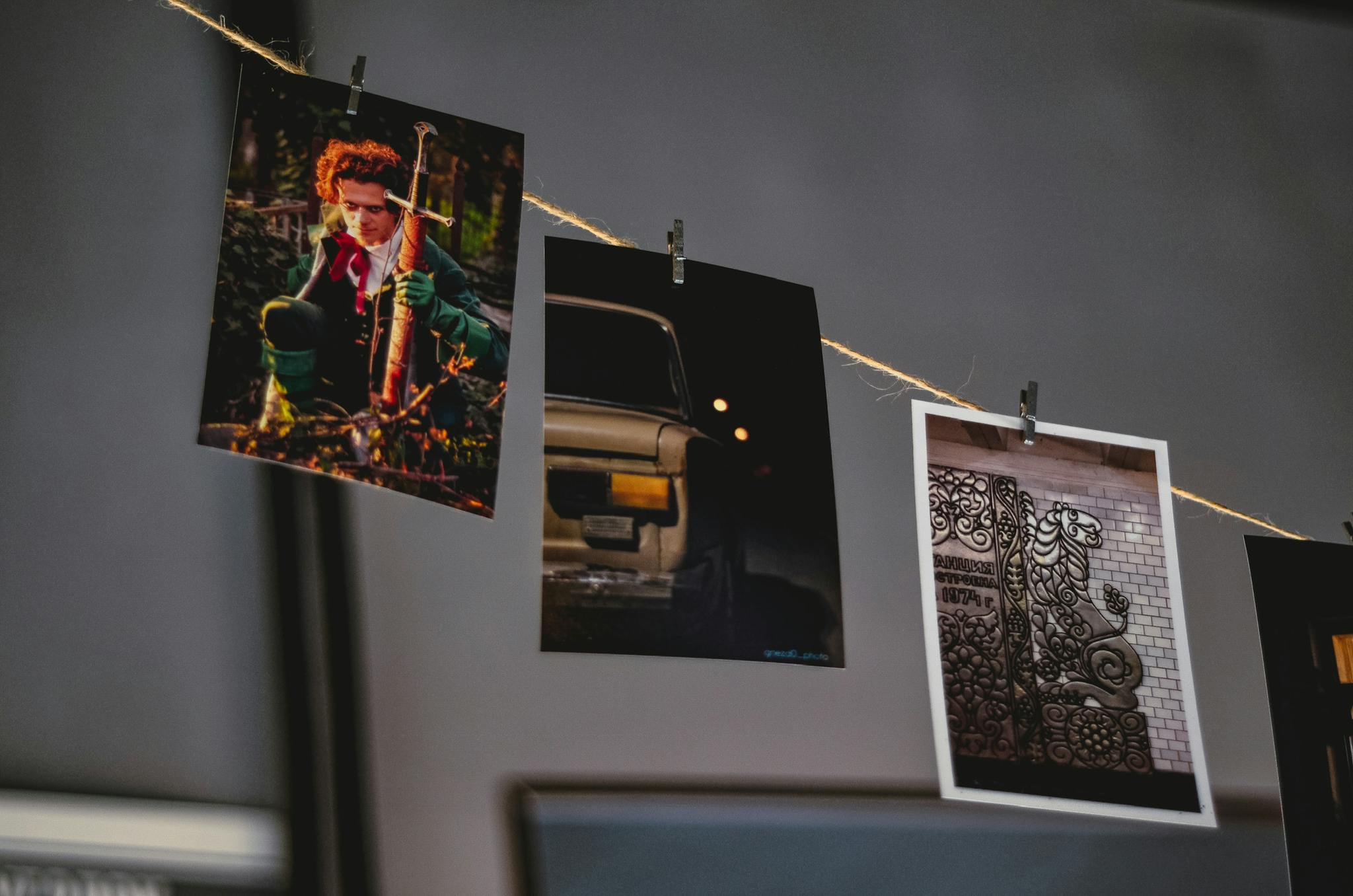 Three photo prints hanging on a string, showcasing different scenes.